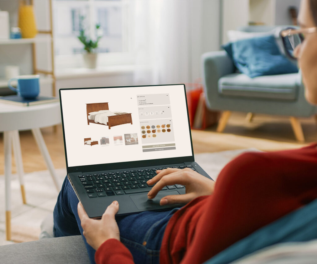 Person browsing custom furniture options for a wood bed on a laptop.